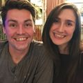 Brother and sister with light brown hair, smiling and sitting close.