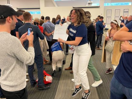 Francie Goodstein leaps with joy as others cheer and look on at OHSU Match Day 2022.