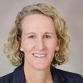 Jeni Johnston, Ph.D. smiles against a light gray background.