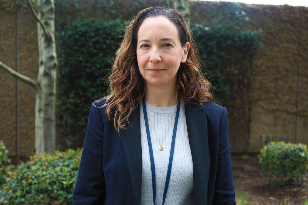 Ana Quinones, Ph.D. (OHSU) stands near trees along the Portland Waterfront.