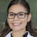 Brenda Rojas (OHSU) stands in a room wearing a lab coat.