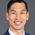 Smiling adult man wearing a necktie and suit.