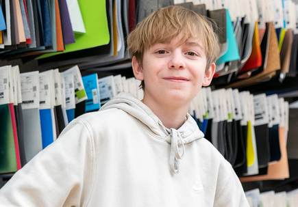 Emerson Harrell stands near fabric swatches.