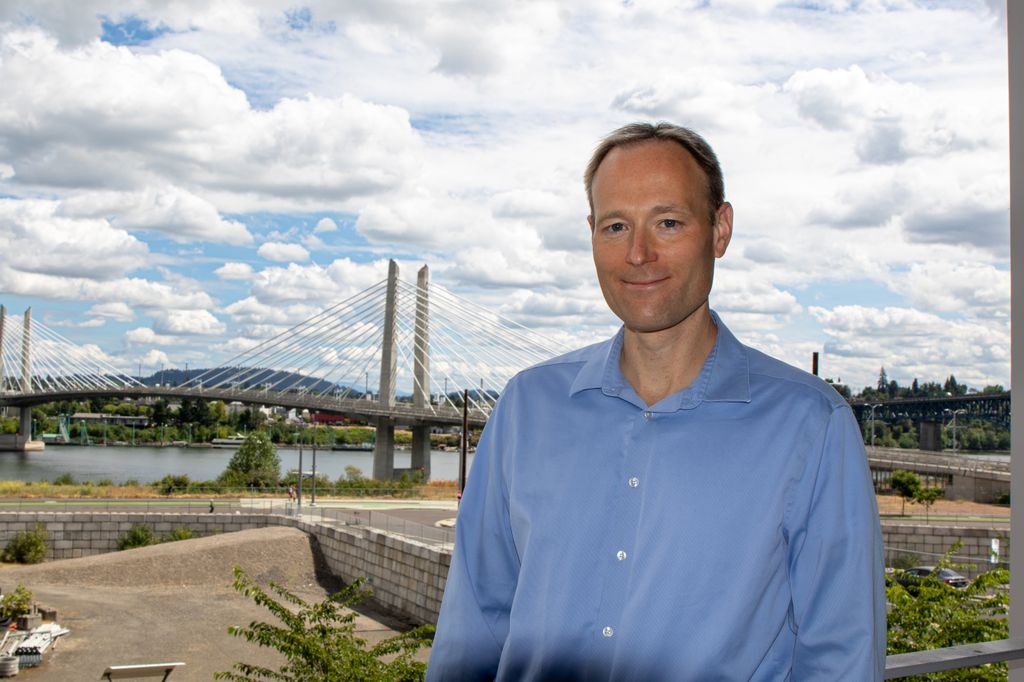 Jeff Tyner, Ph.D. stands in front of a bridge in the distance