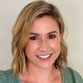 Katelin Ross smiles against a white wall.