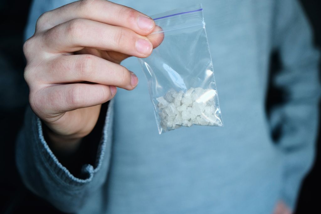 Person holds a bag of rock meth.