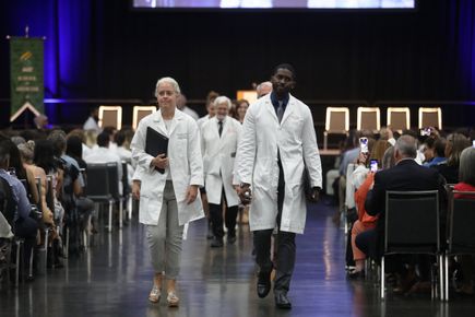 Tracy Bumsted, M.D., M.P.H., associate dean for undergraduate medical education; Antwon Chavis, M.D., assistant professor of pediatrics who led the Oath of Geneva; David Jacoby, M.D., interim dean, OHSU School of Medicine, led the recessional after the ceremony. (OHSU/Christine Torres Hicks)