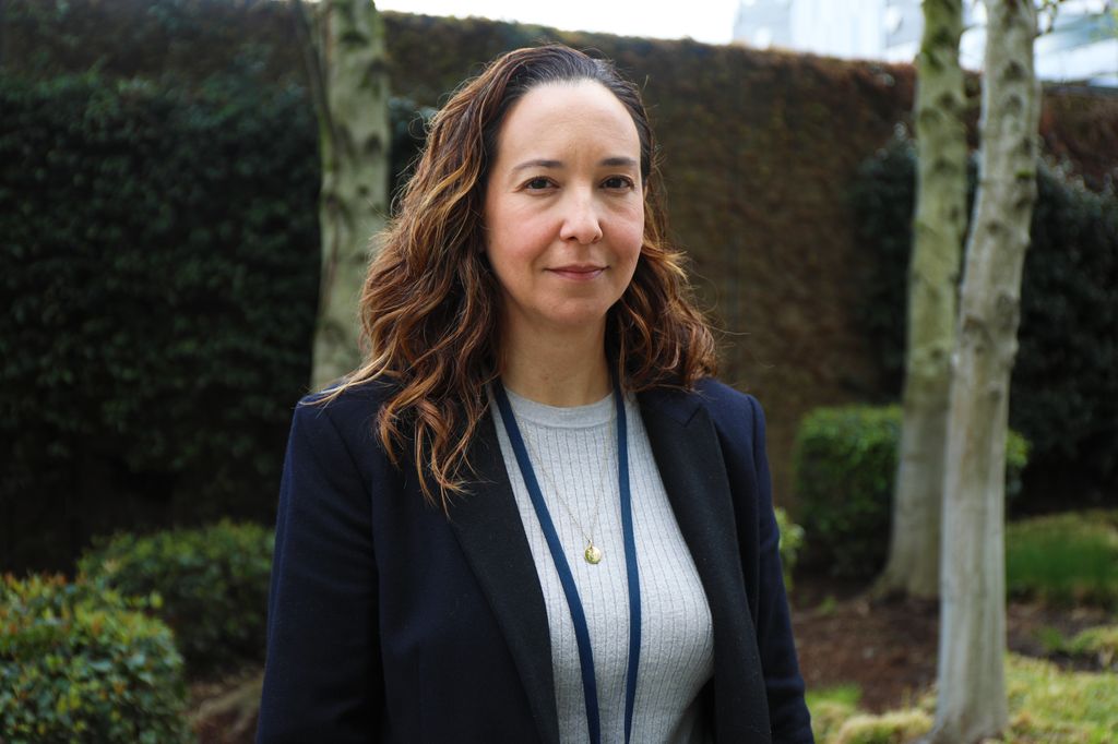Ana Quinones, Ph.D., stands near greenery at OHSU.
