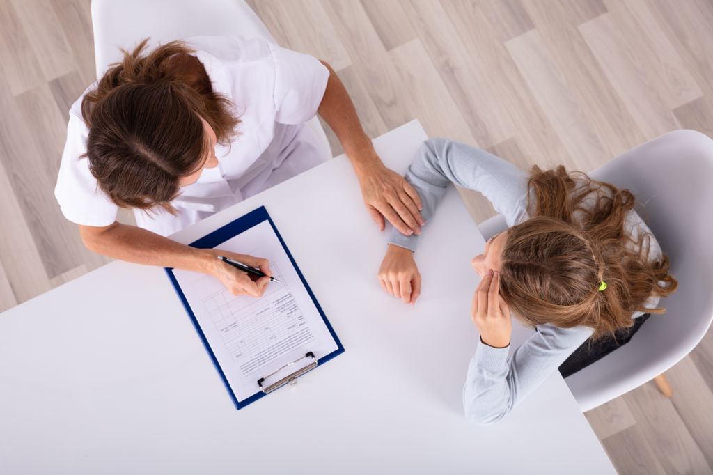 A doctor works with a girl on concentration studies and other tests for ADHD.