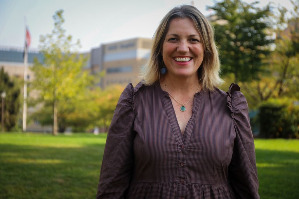 Colleen Reuland, M.S., stands on the lawn on Marquam Hill with OHSU Hospital in the background on Mon. Oct. 17, 2022. 