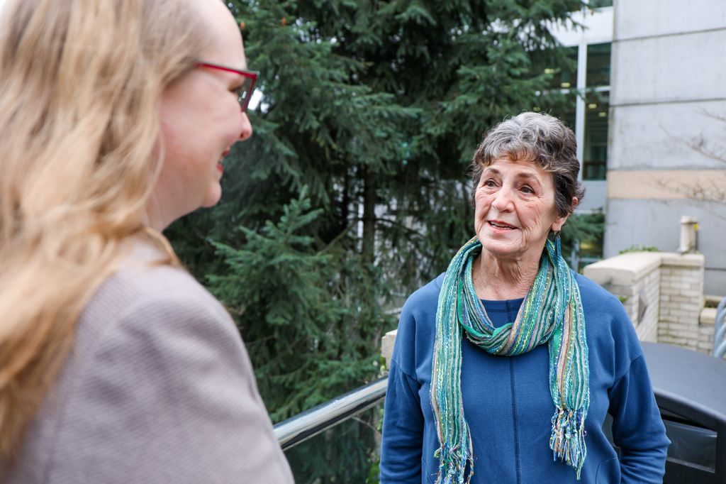 Barbara Klausman de Vancouver, a la derecha, saluda a Aimee Pierce, M.D., cuando llega el miércoles para su infusión regular como parte de un ensayo clínico diseñado para prevenir la enfermedad de Alzheimer antes de que surjan los síntomas. (OHSU/Christine Torres Hicks)