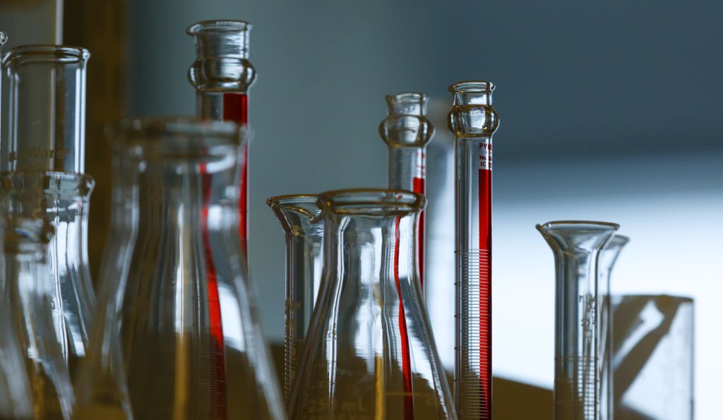 Image is of several glass chemistry bottles in a dim-lit lab. Three scientists at Oregon Health & Science University have earned unrestricted funding to extend leading-edge research to ultimately improve human health. (OHSU)
