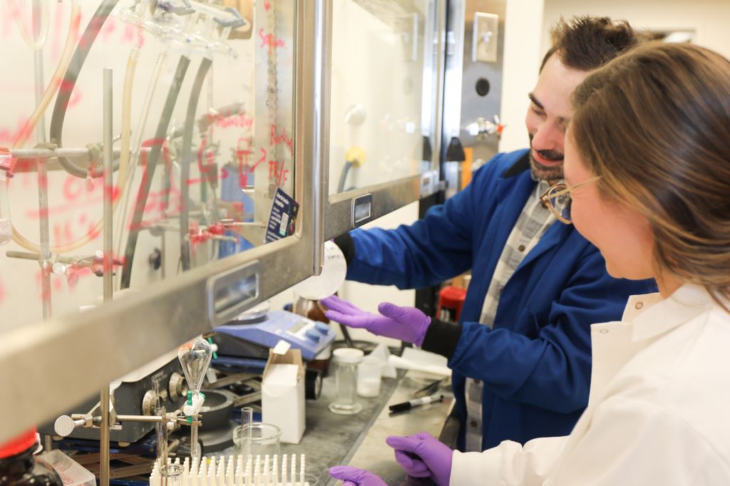 Michael Cohen, Ph.D., en su laboratorio con Moriah Arnold, MD/estudiante de doctorado y coautora del estudio en el que se descubrió una nueva clase de inhibidores de la PARP-1. (OHSU/Christine Torres Hicks)