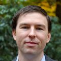 Dan Hoover, M.D., tiene el pelo castaño corto, viste un traje y sonríe en un jardín de OHSU.