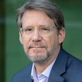 Skip Bohm, director designado de la ONPRC, tiene cabello corto castaño claro, gafas y traje.