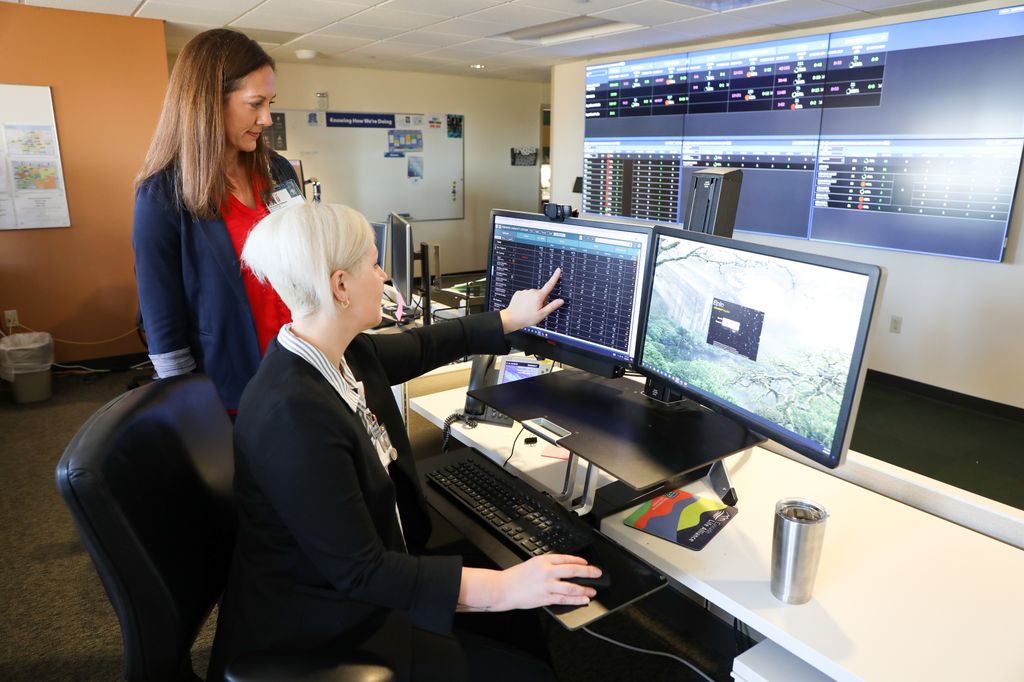 OHSU's director of Mission Control, Stephanie Gilliam,&nbsp;MN, RN, NE-BC, and Rachel Adair, assistant director, MSN, RN, look over new in-patient&nbsp;mental health care data. The Oregon Behavioral Health Coordination Center allows mental health care providers in the Portland region to see behavioral health bed capacity—the same tool that OHSU and partners developed to help coordinate hospital bed availability during the peak of the coronavirus pandemic. The new capacity tool is the first phase in addressing another public health crisis, mental health care. (OHSU/Christine Torres Hicks)