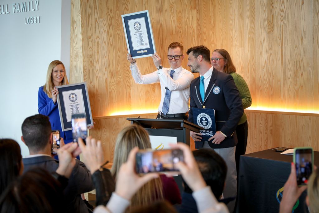 La Dra. Joanna Ludzik, Ph.D., y el Dr. Alexander Witkowski, Ph.D., reciben el certificado oficial del juez de Guinness World Records, en presencia de Christy Staats, paciente de OHSU. (OHSU/Christine Torres Hicks)