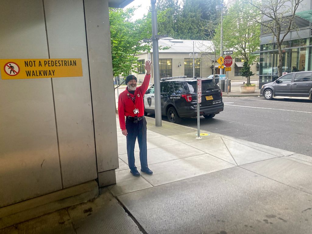 El encargado del estacionamiento Mehrdad Ramezan Baik frente a la entrada del estacionamiento del Center for Health & Healing en Oregon Health & Science University. En un día cualquiera, llega a interactuar con hasta 600 pacientes. (OHSU/Chris Lydgate)