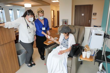 Nurse practitioner Sandra Youngworth, D.N.P., left, and clinical research coordinator Vicki Abtin assist patient Rhonda Stranz at an appointment on Oct. 9. (OHSU/Christine Torres Hicks)