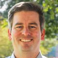 Joshua Lupton, M.D., has short light hair, a dress shirt and standing near OHSU Hospital.