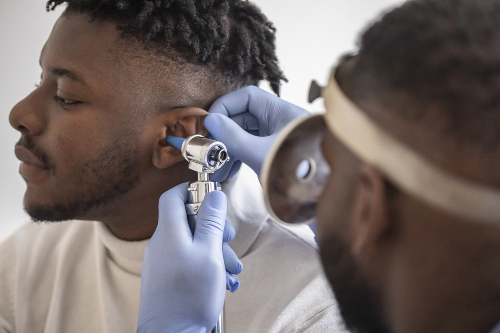 A doctor looks inside a person's ear. OHSU researchers are studying&nbsp;why a common antidepressant medication may worsen tinnitus. (Getty Images)