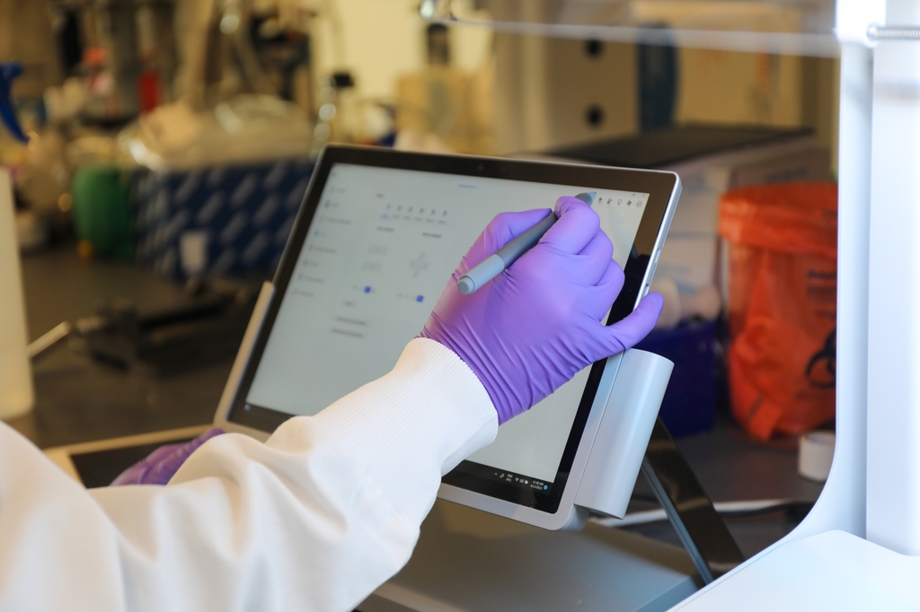 A researcher taps on a digital screen. Three OHSU scientists are the recipients of the 2024 Faculty Excellence and Innovation Awards. Early or mid-stage investigators are nominated and selected by OHSU deans, directors, and department chairs. (OHSU/Christine Torres Hicks)
