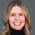 Bonnie Nagel, Ph.D. (OHSU) has long dark blonde hair, a black sweater and is smiling against a gray background.