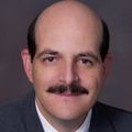 John Vetto, M.D., wearing a suit and tie, smiling.