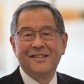 Ron Sakaguchi, Ph.D., D.D.S., tiene cabello corto y oscuro, anteojos y un traje negro con parte superior blanca, sonriendo en OHSU.