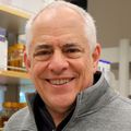 Louis Picker, M.D. tiene el pelo corto y blanco y sonríe en el laboratorio de Frueh. Louis Picker, M.D., profesor del Instituto de Terapia Génica y Vacunas de OHSU, investiga el potencial de las vacunas basadas en citomegalovirus. Con sus colegas Klaus Früh, Ph.D., y Scott Hansen, Ph.D., ambos en VGTI, descubrieron que su plataforma de vacunas es prometedora como "escudo" contra el cáncer.