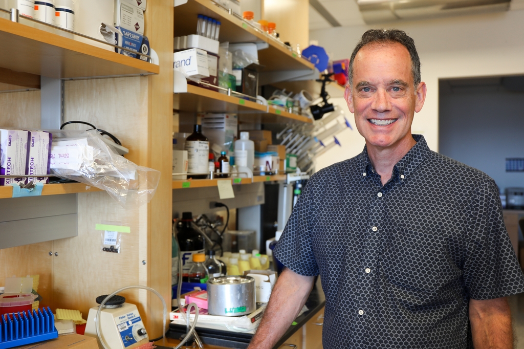 Tom Scanlan tiene el pelo corto, rizado y oscuro y está de pie en su laboratorio. Tom Scanlan, Ph.D., en su laboratorio de la Universidad de Ciencias y Salud de Oregón. Autobahn Therapeutics, una empresa fundada por primera vez en el laboratorio OHSU de Scanlan, ha atraído una inversión de 100 millones de dólares para desarrollar nuevos tratamientos para el trastorno depresivo mayor y la depresión bipolar, con el objetivo de abordar la necesidad clínica de mejores tratamientos para estas afecciones que afectan a millones de personas. (OHSU/Christine Torres Hicks)&nbsp;