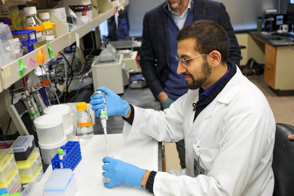André L. Lira, Ph.D., en un laboratorio de ingeniería biomédica, trabajando con pipeteo y trabajos de laboratorio. André L. Lira, Ph.D., académico de posgrado, trabaja en un laboratorio de ingeniería biomédica. Lira es parte de un equipo de OHSU que ha descubierto cómo una molécula que se encuentra en ciertas bacterias podría ser la clave para mejorar las intervenciones para millones de pacientes con septicemia. (OHSU/Christine Torres Hicks)