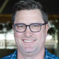 Benjamin Burwitz, Ph.D. has short brown hair, eye glasses, a blue shirt and smiling.