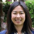 Jane Zhu, M.D., has shoulder-length black hair, a blue blazer and white top, smiling in a garden at OHSU.