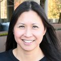 Jamie Lo, M.D., M.C.R. (OHSU) has long dark hair, is wearing a black top, and is standing in a garden at the OHSU Center for Health and Healing..