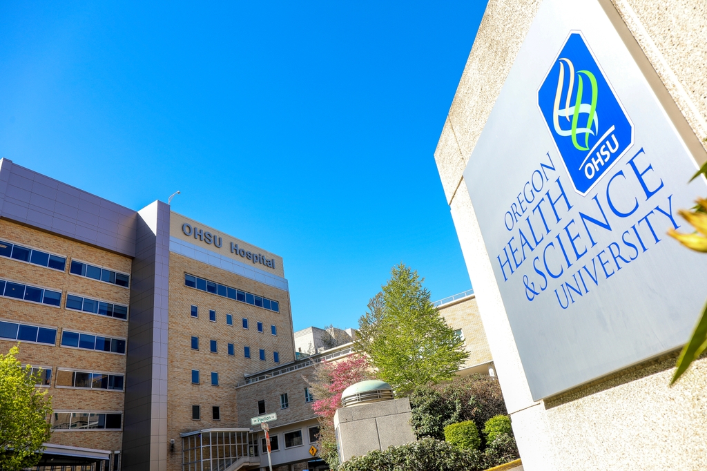 Image is of OHSU Hospital and the Oregon Health and Science University stone sign. Oregon Health & Science University and hospitals around the state continue to operate at extremely high capacity. (OHSU/Christine Torres Hicks)