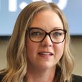Claudia Aime, D.N.P., RN, has wavy blonde hair, eye glasses, a black blazer and speaking at the roundtable.