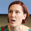 Mary Tanski, M.D., has short, cropped red hair, a multicolor dress and is speaking at a roundtable panel with the OHSU logo behind.