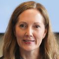 Stephanie Gilliam, M.N., RN, has long straight honey-blonde hair, a black blazer, speaking on a roundtable panel with the OHSU logo on a screen behind.