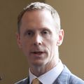 Carl Eriksson, M.D., has short blonde hair, and is wearing a blue suit with yellow tie, speaking.