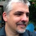 Andrew Chitty, M.B.A., has short gray hair, gray chin hair and gray mustache.