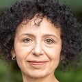 Rodica Busui, M.D., Ph.D., tiene cabello corto, oscuro y rizado y viste un abrigo a cuadros blanco y negro.