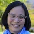 Miranda Lim, M.D., Ph.D., tiene cabello negro corto y lacio, una bufanda azul y una blusa negra.