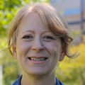 Lisa Silbert, M.D., tiene cabello rojo claro recogido hacia atrás y una blusa azul, sonriendo en OHSU.