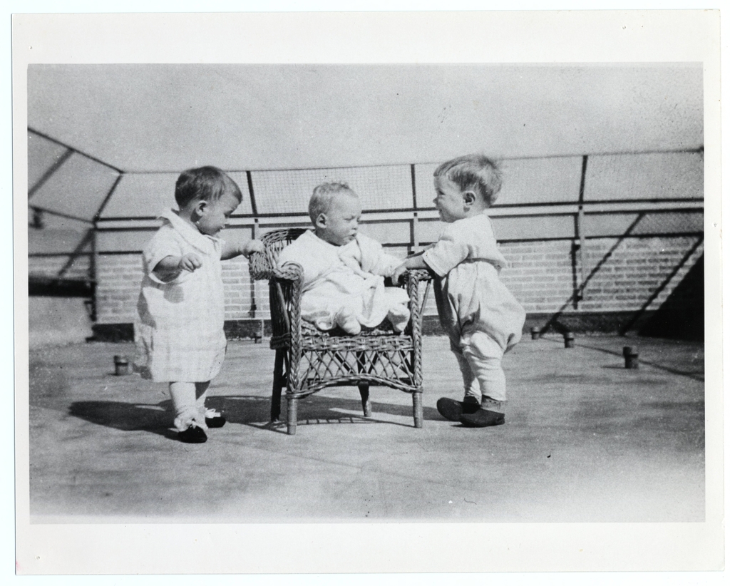 DCH 100 years: Three infants in an outdoor fenced area 