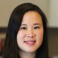 Fei Cai, M.D. (OHSU) Fei has long black hair and is wearing a black sweater over a dress, in a labor room at OHSU.