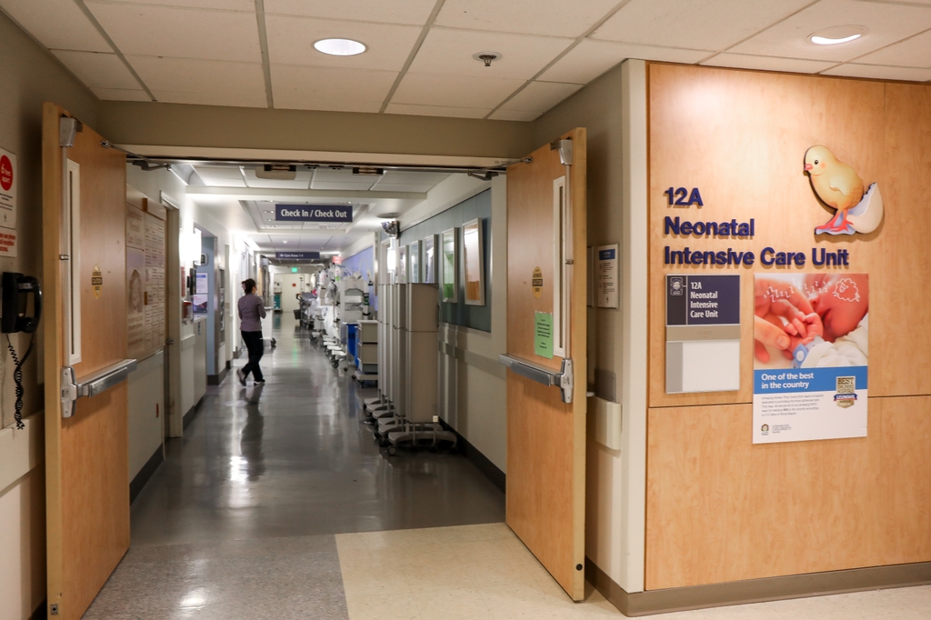 El letrero y las puertas de la NICU de OHSU se abren y pasa una enfermera.