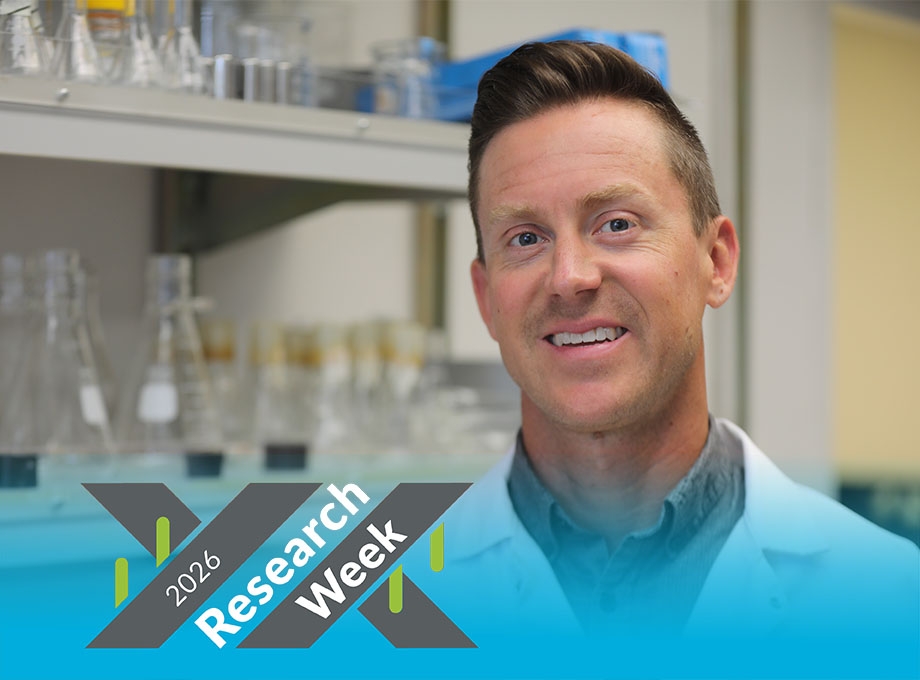Jonathan, wearing a white coat, smiles in his lab.