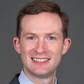 Stephen Bowden, M.D. (OHSU) Stephen has short brown hair, a gray suit and smiling against a gray/brown background.