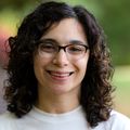 Sarah Efron (OHSU) Sarah has short black curly hair, eye glasses and is wearing workout clothes, smiling in a park near her home.